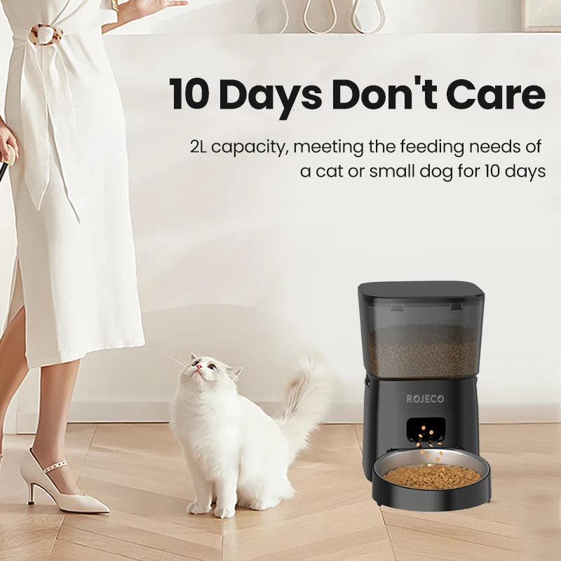 Cat sitting next to a black pet feeder with text about its capacity and usage duration.